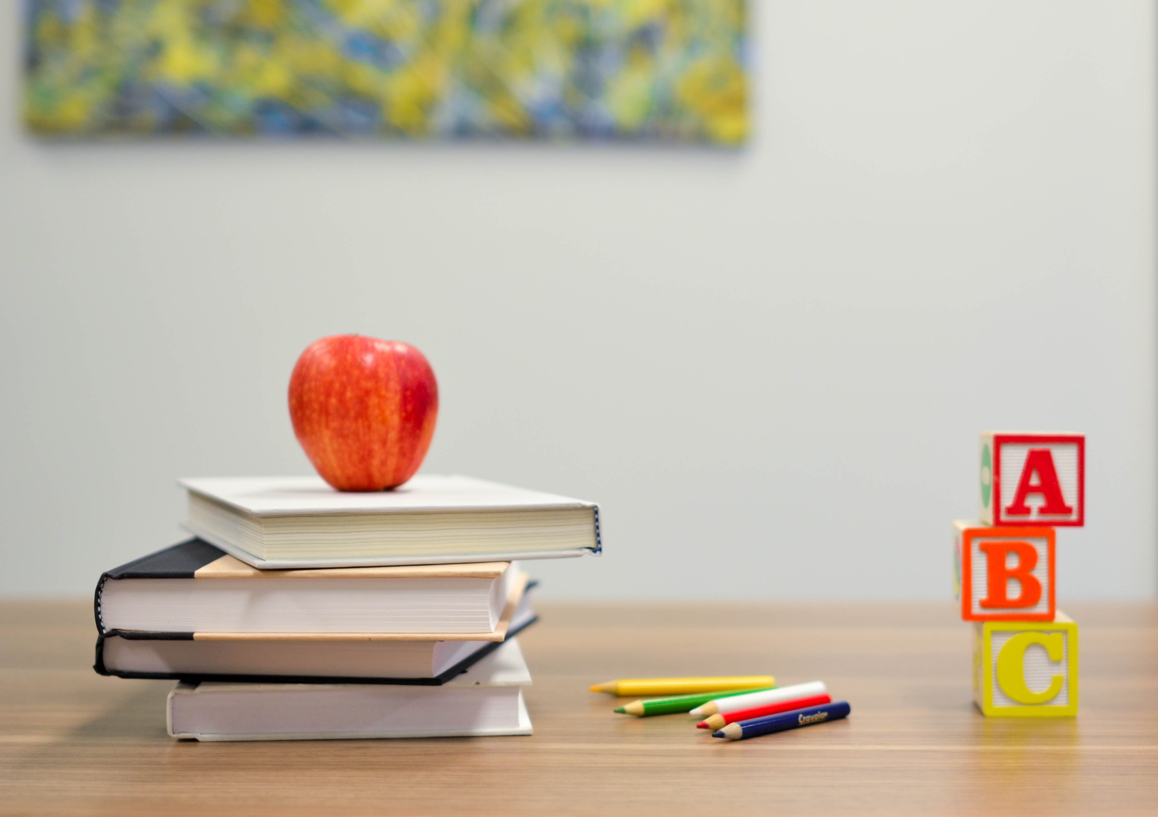 photo of school books and apple on a desk